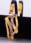 Conjunto de par de brincos e pulseira, no feitio de junco, em ouro 18k - 750 mls contrastado nos brincos, provavelmente italiano, sendo a pulseira decorada com 3 ametistas ovais. Peso: 53,2 g. Comp. dos brincos: 2,8 cm. (Pequenas mossas na pulseira).