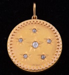 Antigo pendente redondo em ouro 18k com 6 brilhantes guarnecidos com lavrados estrela, sendo o central com aproximadamente 0,15ct. Diâm.: 3cm. Peso: 5,5g.