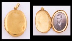Antigo guarda lembrança oval em ouro 18k. Alt.: 2,7cm. Peso bruto: 5,9g. Apresenta foto e inscrições internas esmaltadas datada de 1909.