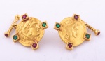Par de antigas abotoaduras ovais em ouro 18k - 750 mls contrastado, com efígie do "Imperador  Júlio Cesar", guarnecido nas laterais com 2 rubis e esmeraldas cada. Comp.: 2,1 cm. Peso: 17,6 g.