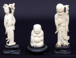 Três figuras esculpidas em marfim, representando "Deusa Kuan Yian", "Imortal com Cajado e Pêssegos" e "Buddah". Bases em madeira. Alt. do maior: 12cm. China (circa 1920).