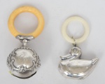 Dois chocalhos de bebê, sendo 1 cilíndrico em prata francesa "Cabeça de Mercúrio" com guarnição em marfim, e o outro no feitio de "Patinho" espessurado a prata. Alt.: 9cm e 8cm.