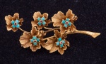 Antigo broche no feitio de ramo de flores em ouro 18k, decorado com contas de turquesas minúsculas. Alt.: 5,7cm. Peso: 10,8g.