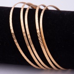 Cinco pulseiras, provavelmente árabes, em ouro 18k com lavrados. Diam. interno: 7,0cm. Peso: 26,4g.
