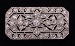 Placa retangular art deco em platina francesa da década de 20/30, com brilhante central e 56 diamantes laterais. Medida: 4 x 2. Peso: 9,2g.