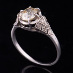 Antigo anel em platina com brilhante central e 12 diamantes nas laterais. Aro: 16/17.