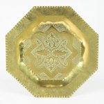 Medalhão oitavado em metal amarelo, provavelmente marroquino lavrado com ramos e arabescos. Diâm.: 50cm.