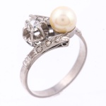 Antigo anel dito "Romeu e Julieta" em ouro branco com 1 brilhante de aproximadamente 0,15ct, pérola de 6mm e 6 diamantes laterais. Aro: 14. Peso: 3,5g.