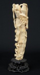 Figura esculpida em marfim, representando "Divindade Kuan Yin com cesto de flores e adereços". Base em madeira trabalhada. Alt.: 31cm. China - 1940.
