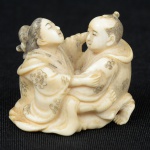 Netsuke esculpido em marfim, representando "Casal em cena erótica". Alt.: 3,3cm. Japão - 1900.