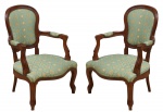 Par de cadeiras de braço em madeira clara, estilo "Luis XV". Moldura do espaldar com parte superior encurvada. Braços e pernas arqueados. Assento e encosto forrados em tecido bege, azul e branco tacheado. Reproduzido com foto no catálogo.