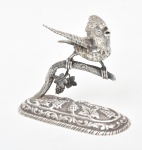 Paliteiro de coleção em prata 925mls contrastada no feitio de pássaro sobre galho de parreiras. Comp.: 12cm. Alt.: 9,5cm. Peso: 180g.