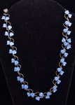 Colar em prata "Sterling" contrastada, provavelmente oriental, ornamentado com delicadas folhas revestidas em esmalte azul. Comp.: 55cm.