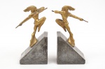 H. TRUCCI (BRASIL-1900). Par de serre livres art deco em bronze dourado representando "Índios com Lança". Base em granito negro. Alt.: 22cm. Assinado.
