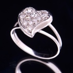 Delicado anel no feitio de coração em ouro branco 18k, arrematado com 10 brilhantes. Aro 15. Peso: 2,6g.