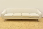JOAQUIM TENREIRO (1906-1992). Excepcional "sofá curvo" para 4 lugares da década de 50/60. Pés de palito em jacarandá. Forração em tecido bege. Comp.: 2,40m.