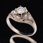 Antigo anel em ouro branco com brilhante central de aproximadamente 0,45ct e 2 brilhantes laterais. Aro: 17. Peso: 2,8g.
