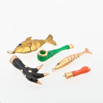 Cinco antigos berloques para balangandã, representando "2 peixinhos, garra de pássaro, cachimbo e figa" de materiais diversos. Guarnições e 1 peixinho em ouro baixo. Peixe maior em vermeil. Comp. do maior: 4,0cm.