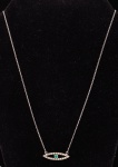 Gargantilha em ouro branco 18k - 750mls contrastado com pendente navete, tendo ao centro esmeralda redonda emoldurada com 20 zircônias redondas.