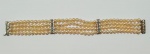 Pulseira de 4 fios com 144 pérolas de aproximadamente 4mm. Fecho e separadores em ouro branco com 12 brilhantes. Comp.: 18cm.