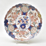 Medalhão em porcelana japonesa "Imari", séc. XIX, esmaltado em rouge de fer com 4 reservas de flores orientais e diagramas. Borda gomada e ondulada. Diâm.: 31cm. (Em função da fragilidade, este lote só poderá ser enviado para fora do estado através de transportadora especializada).