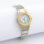CARTIER. Relógio feminino suíço de pulso da marca "Cartier", modelo "Santos Ronde". Caixa e pulseira em aço e ouro. Movimento automático. Moldura do mostrador oitavada. Diâm.: 2,3cm. Funcionando.