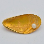 Antigo broche em ouro 18k no feitio de "marisco", finamente cinzelado no fundo com "Prédio da Ilha Fiscal", guarnecido com pérola de aproximadamente 4mm. Medida: 3,5 X 1,5. Peso: 2,8g.