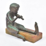 ESCOLA EUROPEIA (SÉC. XIX). "O Menino Fauno Encantando Pássaro com a Flauta", escultura miniatura em bronze patinado. Base em ônix. Alt.: 8cm. Comp.: 10cm.