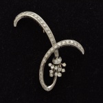 Antigo broche em platina no feitio de "ramo de flor", ornamentado com 52 diamantes, totalizando aproximadamente 1,0ct. Alt.: 5,5cm. Peso: 10,7g.