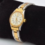 BAUME & MERCIER. Relógio feminino suíço de pulso com calendário da marca "Baume & Mercier". Caixa e pulseira em aço e ouro. Funcionando. Movimento automático. Diâm.: 3,4cm.