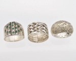 Três anéis em prata de lei, sendo 1 decorado com pedras verdes. Aro: 20 (2) e 13. Peso: 19,4g.